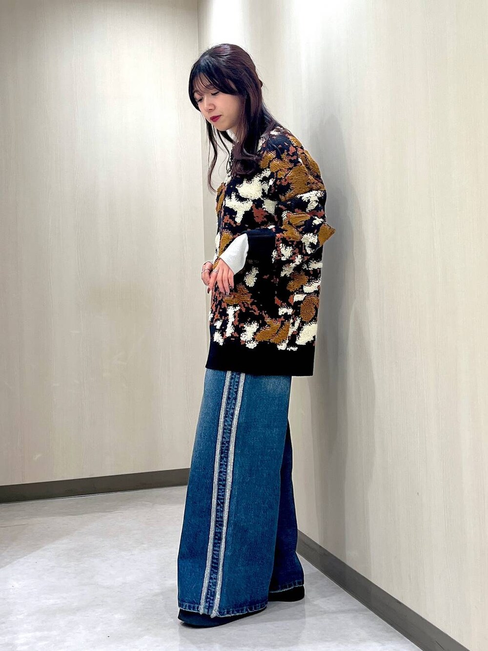 ブルー系のデニムパンツ、ブルー系のニット/セーター、ブラック系のネックレスを着用したレディースの冬コーディネートの2枚目の写真