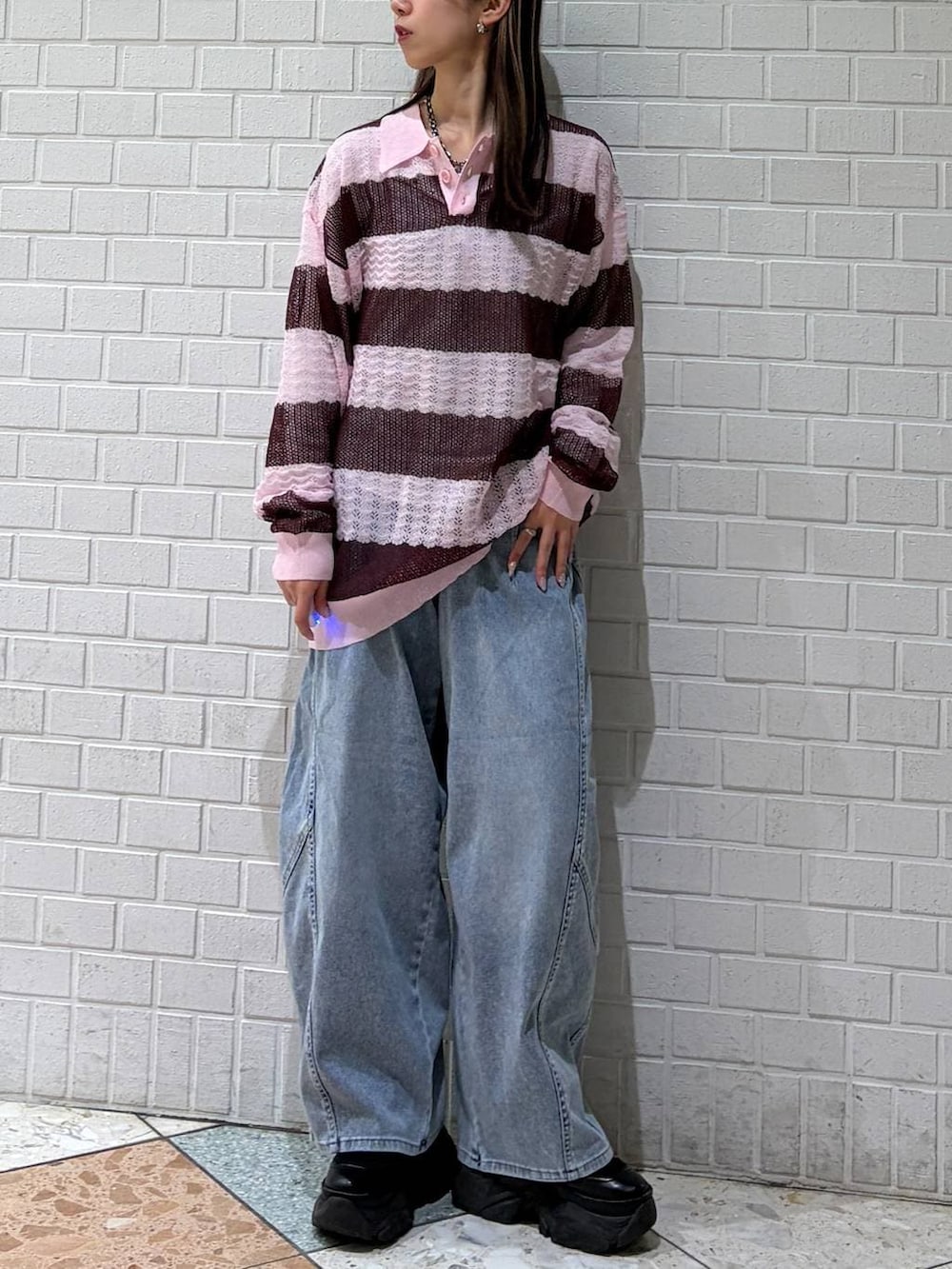 ブルー系のデニムパンツ、ピンク系のポロシャツを着用したレディースの春コーディネートの4枚目の写真