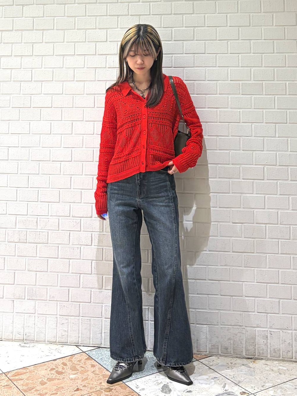 ブルー系のデニムパンツ、ブラウン系のハンドバッグ、ブラウン系のサンダルを着用したレディースの春コーディネートの4枚目の写真