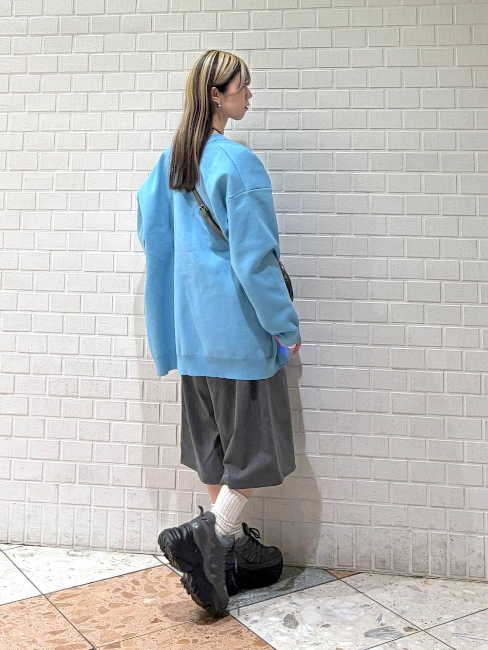 グレー系のスニーカー、グレー系のショルダーバッグ、グレー系のスラックスを着用したレディースの春コーディネートの6枚目の写真