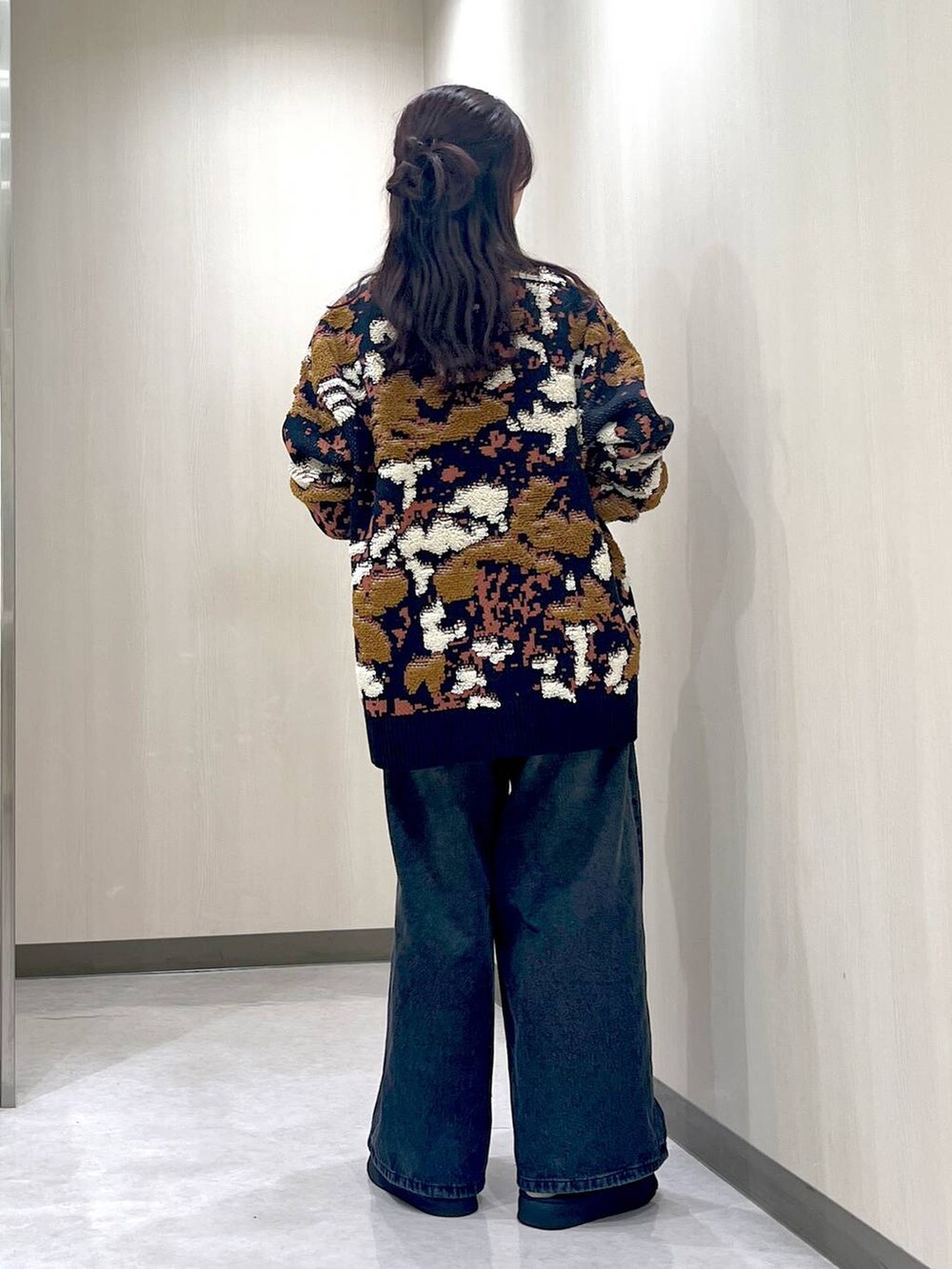 ブラック系のデニムパンツ、ブルー系のニット/セーター、ブラック系のネックレスを着用したレディースの冬コーディネートの3枚目の写真