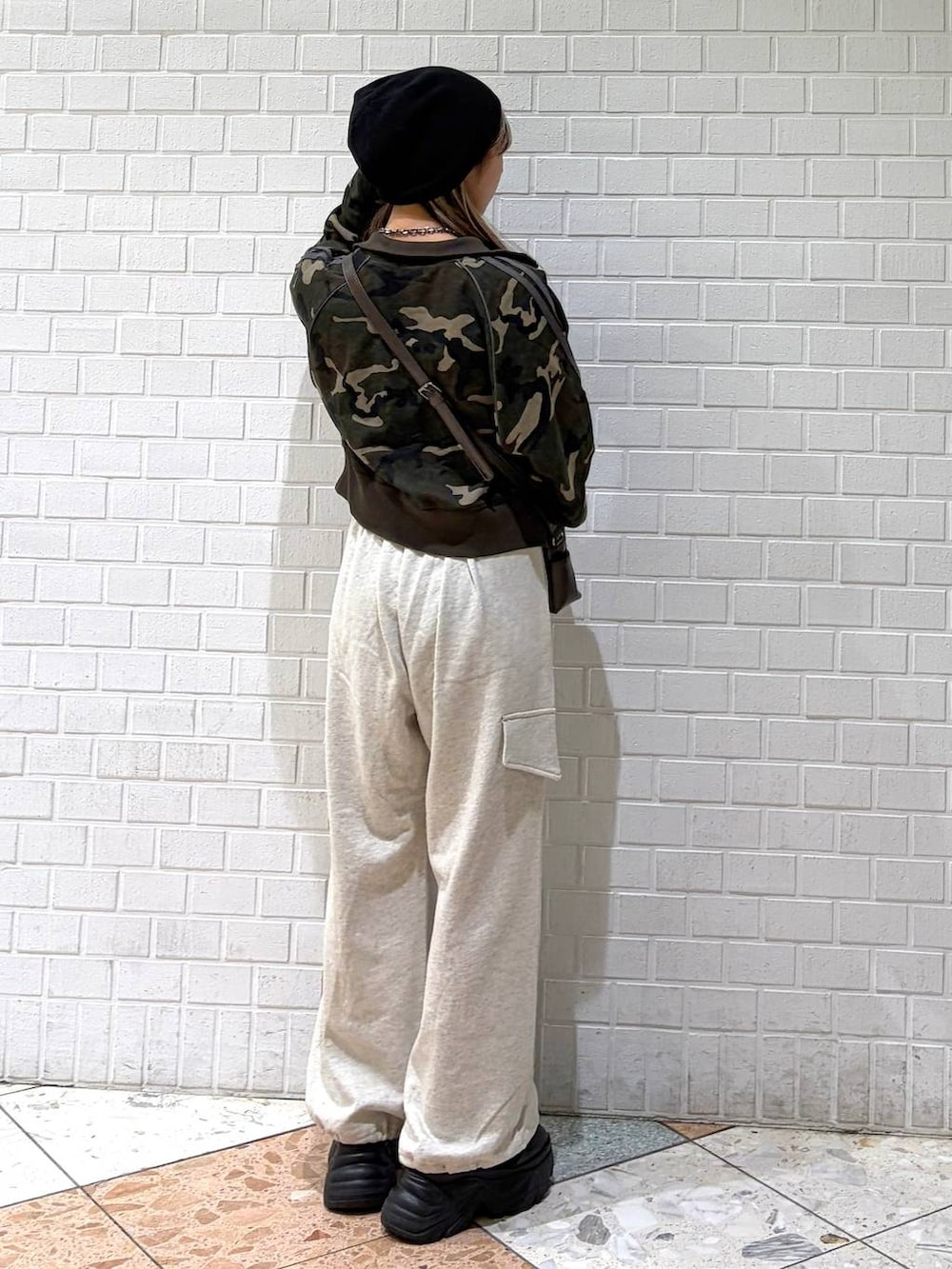 ブラック系のブーツ、ブラウン系のショルダーバッグ、グリーン系のジャージを着用したレディースの春コーディネートの3枚目の写真