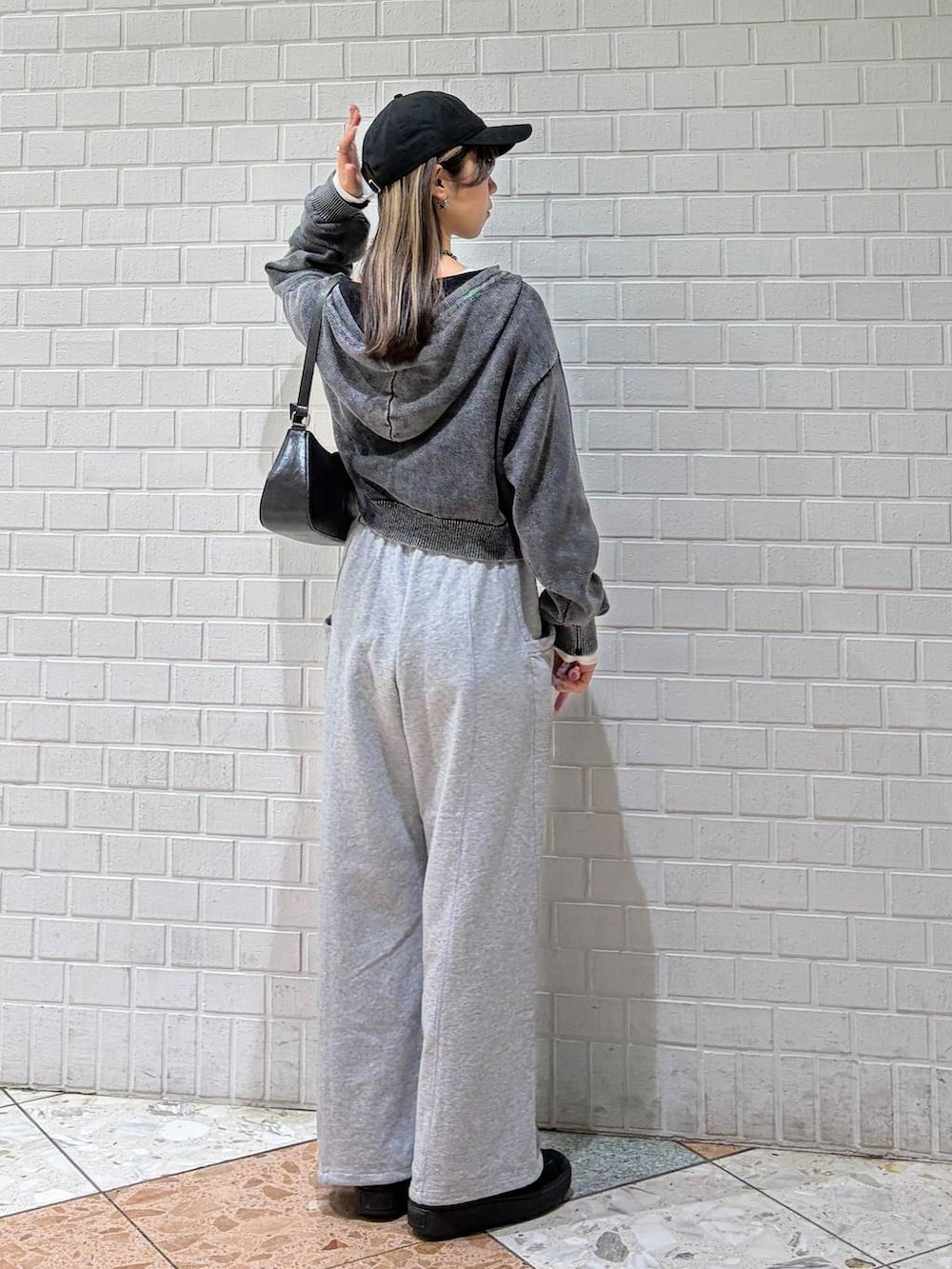 ブラック系のハンドバッグ、グレー系のスウェットパンツ、グレー系のパーカーを着用したレディースの冬コーディネートの2枚目の写真