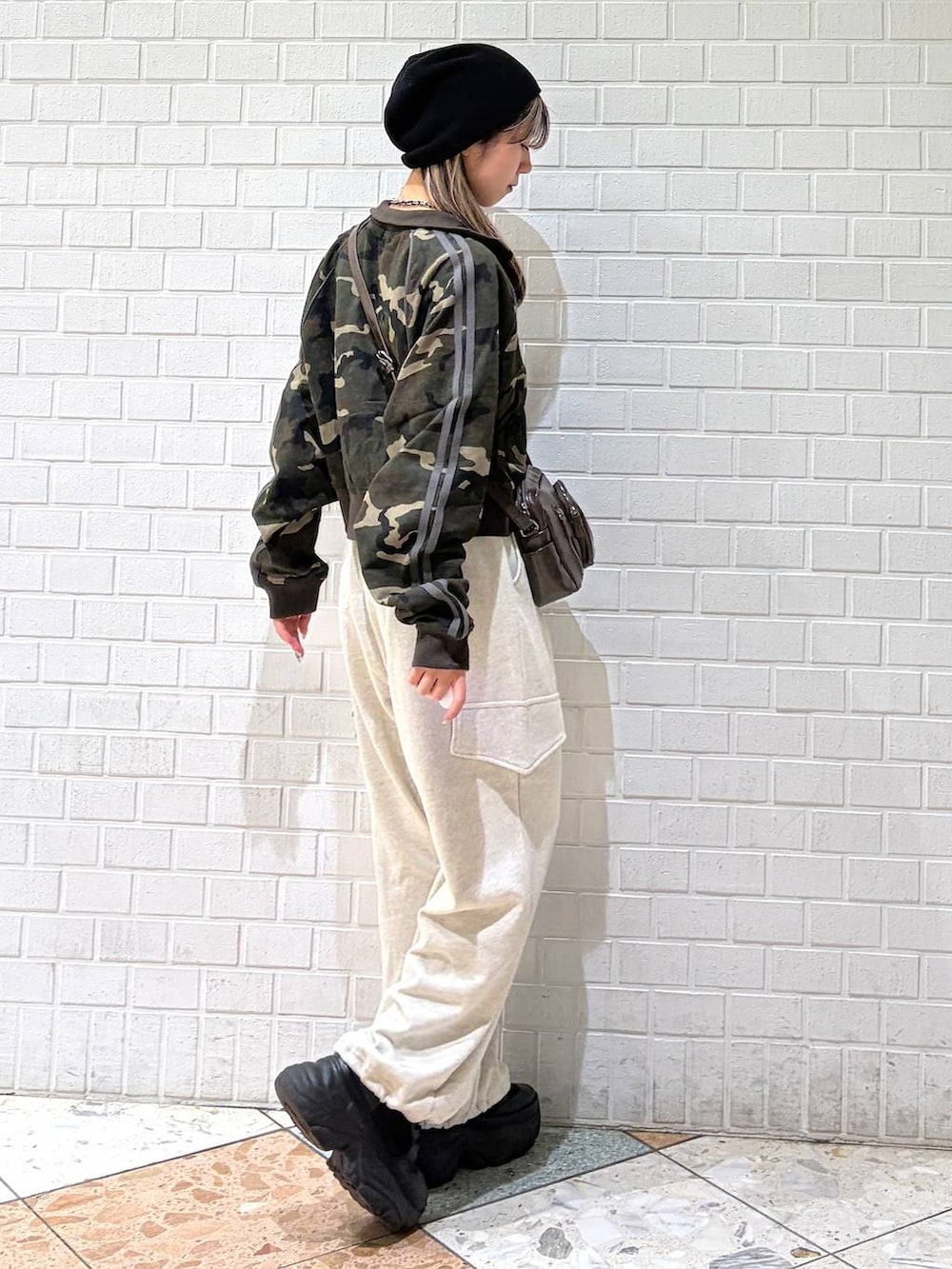 ブラック系のブーツ、ブラウン系のショルダーバッグ、グリーン系のジャージを着用したレディースの春コーディネートの6枚目の写真