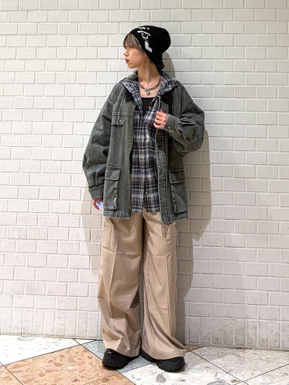 ブラック系のブーツ、ベージュ系のスラックス、ブラック系のシャツ/ブラウスを着用したレディースの春コーディネートの7枚目の写真