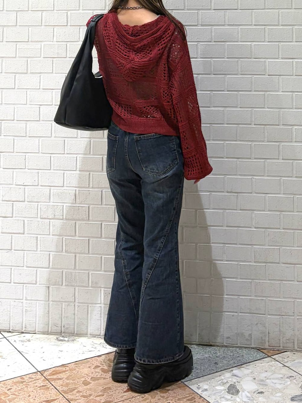 ブラック系のスニーカー、ブルー系のデニムパンツ、ブラック系のトートバッグを着用したレディースの春コーディネートの3枚目の写真