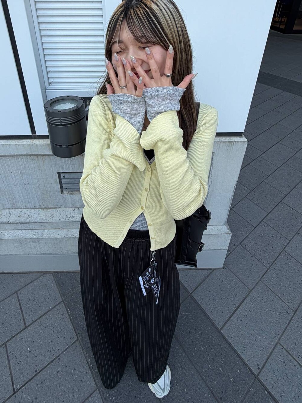 ブラック系のスラックス、グレー系のTシャツ/カットソーを着用したレディースの春コーディネートの4枚目の写真