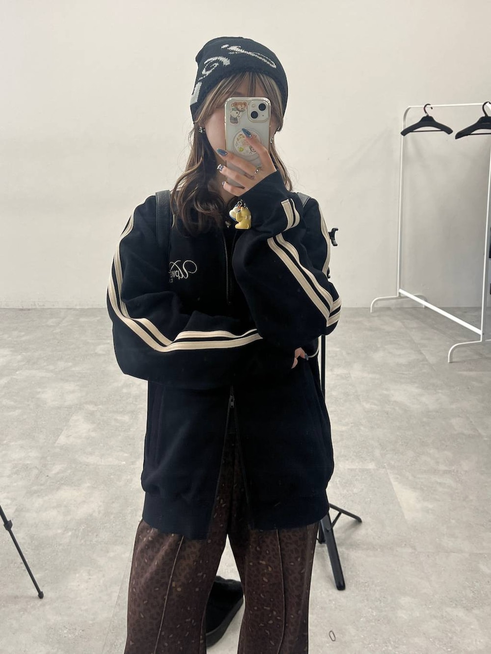 ブラウン系のブーツ、ブラック系のショルダーバッグ、ブラック系のジャージを着用したレディースの冬コーディネートの4枚目の写真