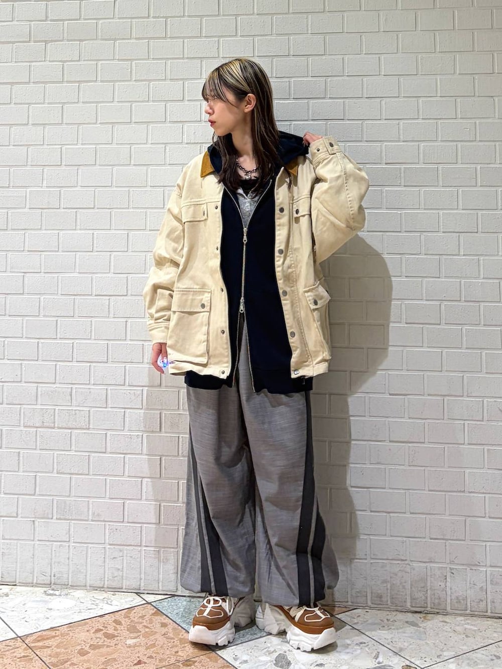 ベージュ系のスニーカー、ブルー系のパーカー、グレー系のその他パンツを着用したレディースの春コーディネートの3枚目の写真