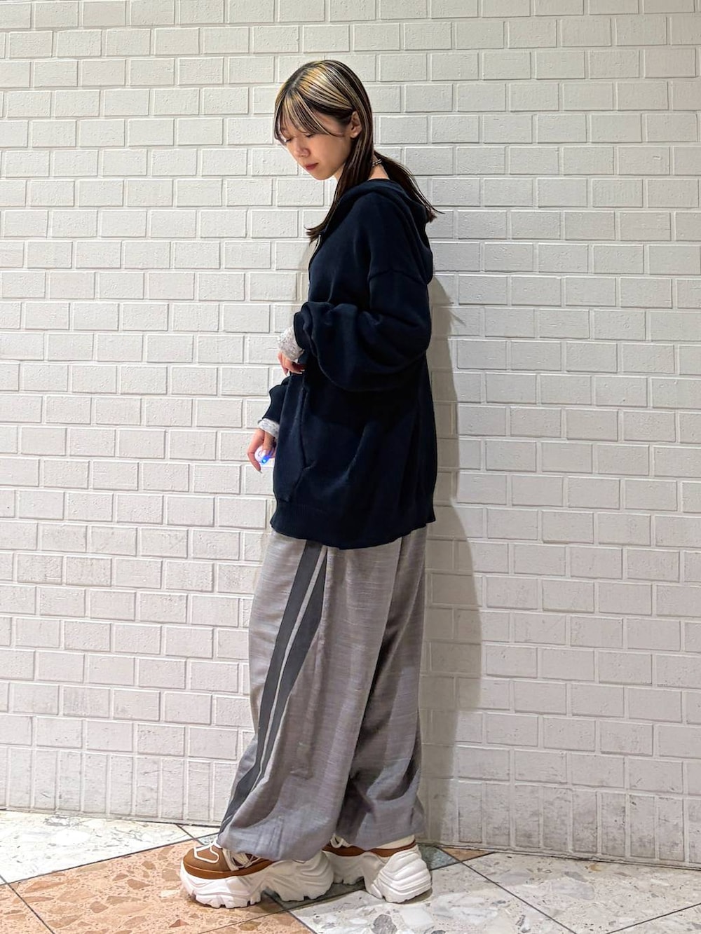 ベージュ系のスニーカー、ブルー系のパーカー、グレー系のその他パンツを着用したレディースの春コーディネートの2枚目の写真