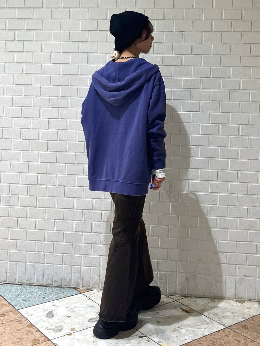 ブラック系のブーツ、ブラウン系のデニムパンツ、ブルー系のパーカーを着用したレディースの秋コーディネートの7枚目の写真