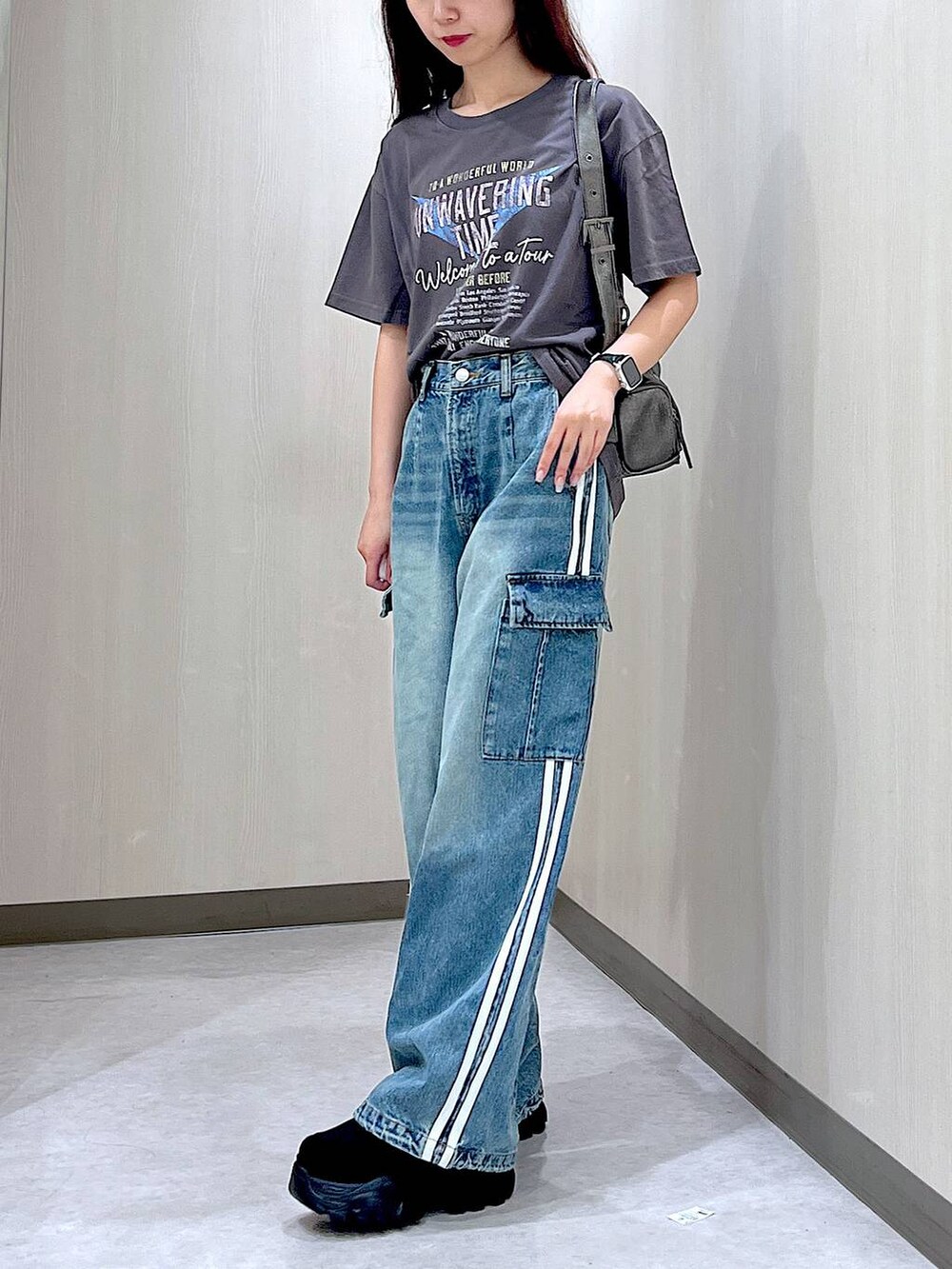 ブルー系のデニムパンツ、ブラック系のスニーカー、グレー系のTシャツ/カットソーを着用したレディースの秋コーディネートの3枚目の写真