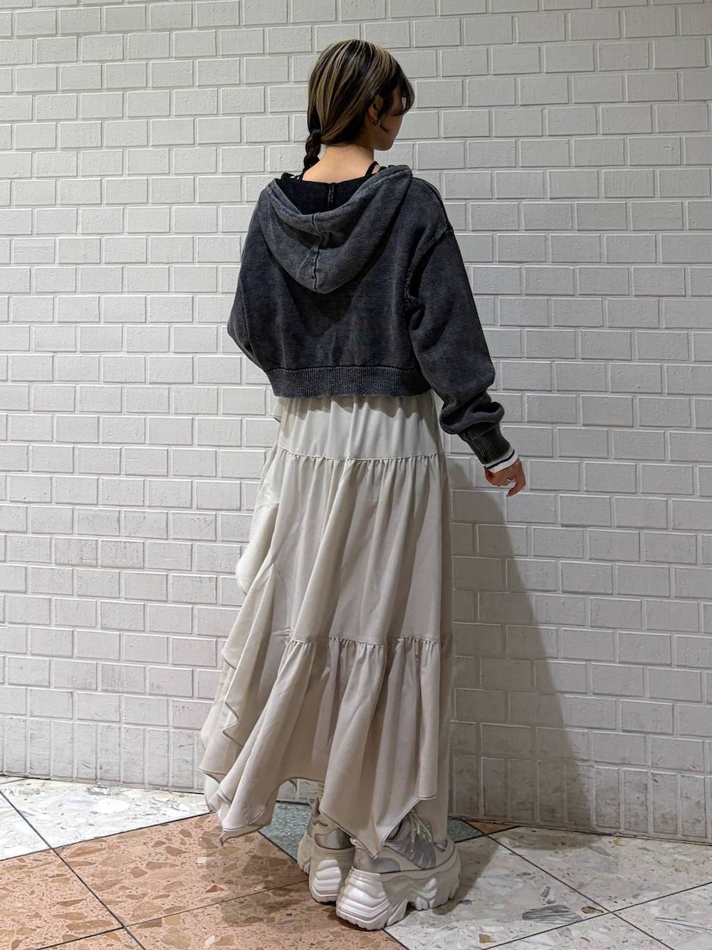 ホワイト系のスニーカー、ベージュ系のスカート、ホワイト系のボストンバッグを着用したレディースの冬コーディネートの5枚目の写真