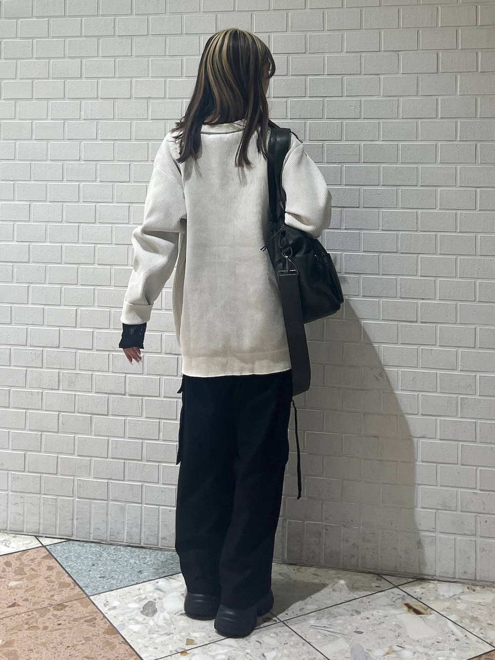 ブラック系のブーツ、グリーン系のボストンバッグ、ブラック系のTシャツ/カットソーを着用したレディースの秋コーディネートの3枚目の写真