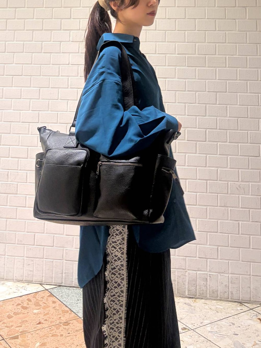 ホワイト系のスニーカー、ブルー系のシャツ/ブラウス、ブラック系のボストンバッグを着用したレディースの秋コーディネートの9枚目の写真