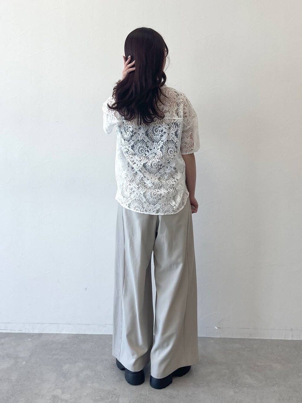 ホワイト系のシャツ/ブラウス、ブラック系のサンダル、ベージュ系のスラックスを着用したレディースの春コーディネートの3枚目の写真