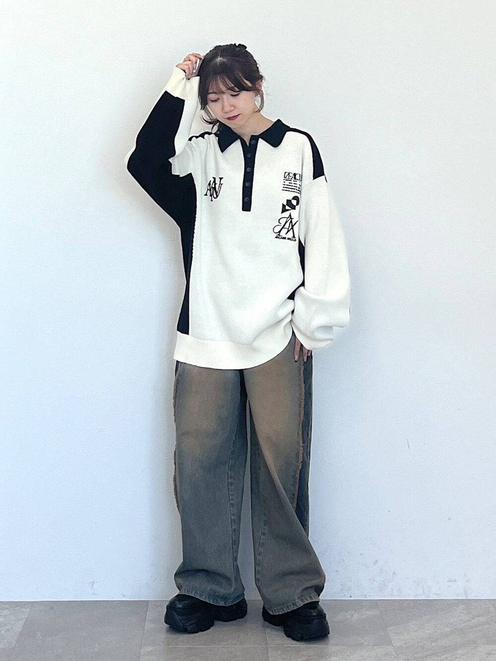 ブルー系のデニムパンツ、ブラック系のブーツ、ブラック系のニット/セーターを着用したレディースの秋コーディネートの4枚目の写真