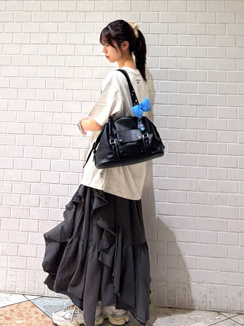 グレー系のスカート、ブラック系のボストンバッグ、ホワイト系のTシャツ/カットソーを着用したレディースの春コーディネートの4枚目の写真