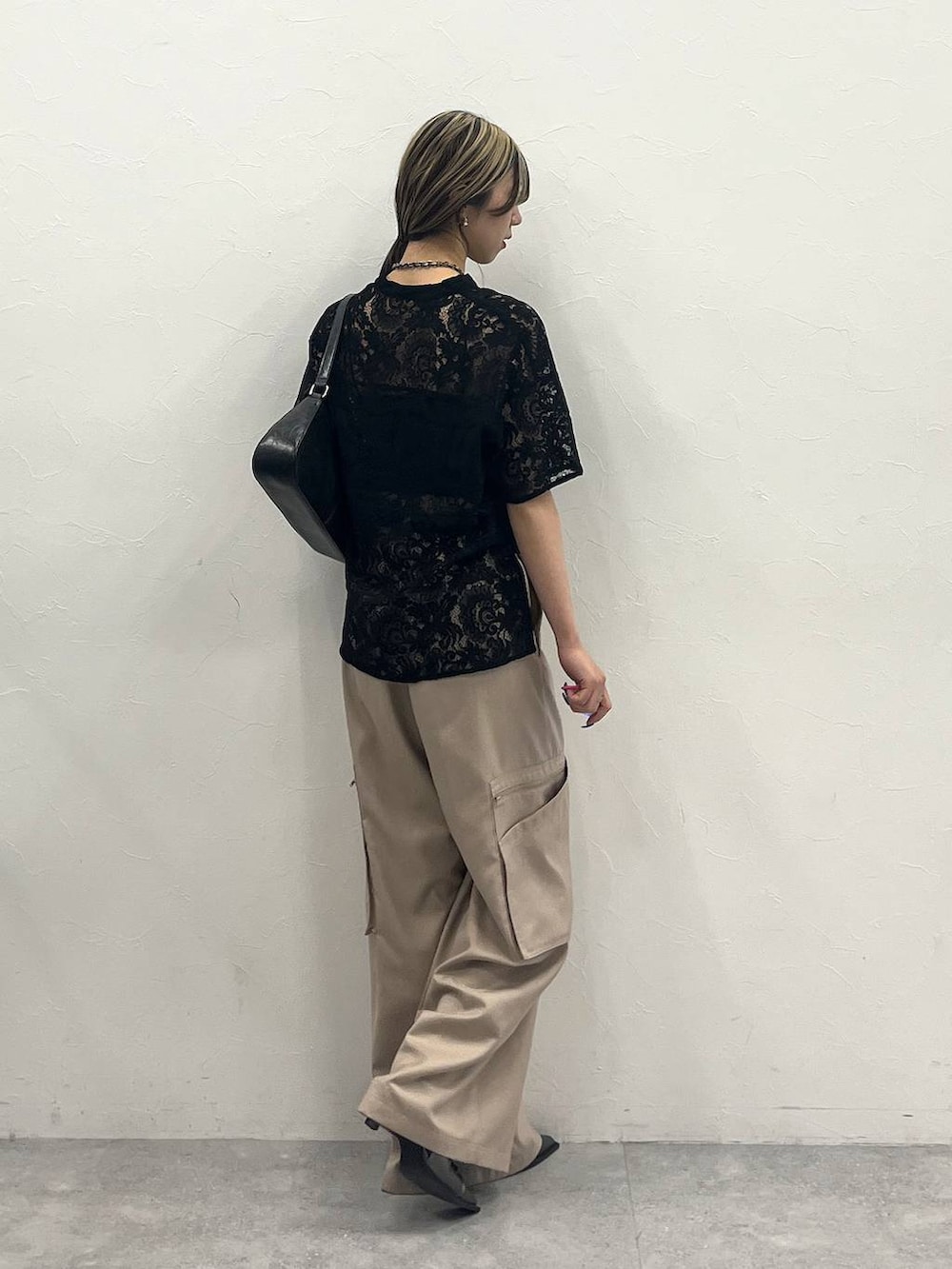 ブラック系のシャツ/ブラウス、ベージュ系のスラックス、ブラック系のハンドバッグを着用したレディースの春コーディネートの5枚目の写真