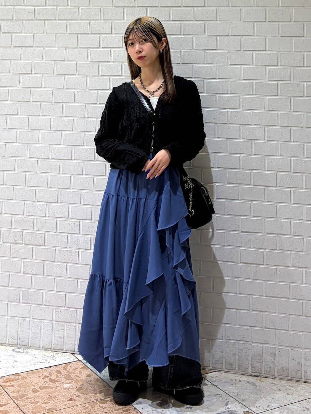 ブルー系のデニムパンツ、ブルー系のスカート、ブラック系のショルダーバッグを着用したレディースの春コーディネートの6枚目の写真