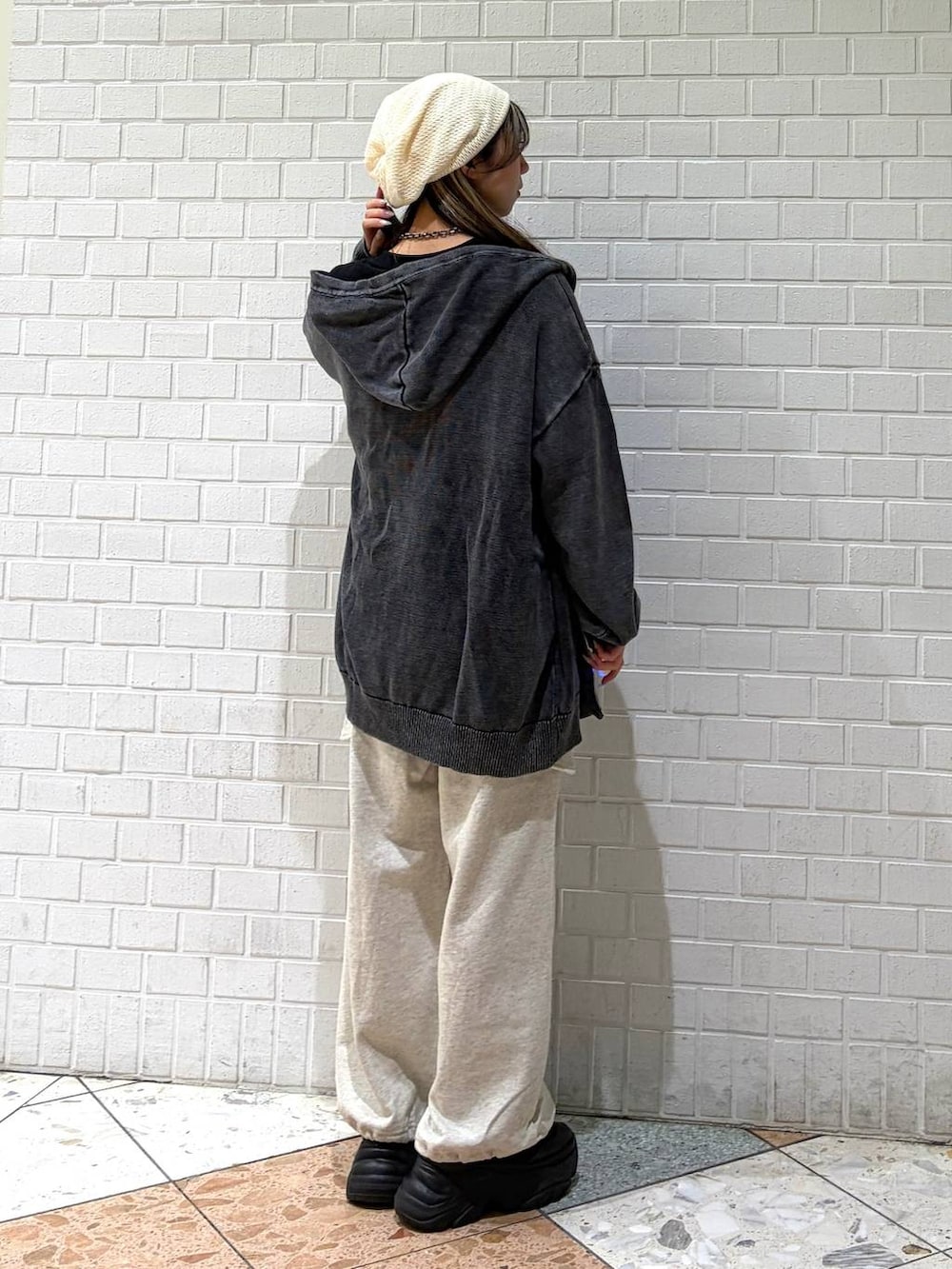 ブラック系のブーツ、グレー系のパーカー、ブラック系のTシャツ/カットソーを着用したレディースの春コーディネートの3枚目の写真