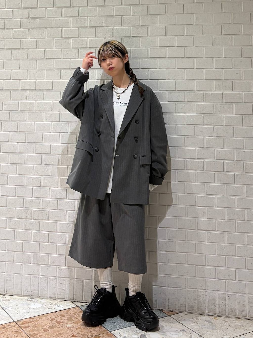 ブラック系のスニーカー、ホワイト系のTシャツ/カットソー、グレー系のスラックスを着用したレディースの春コーディネートの8枚目の写真