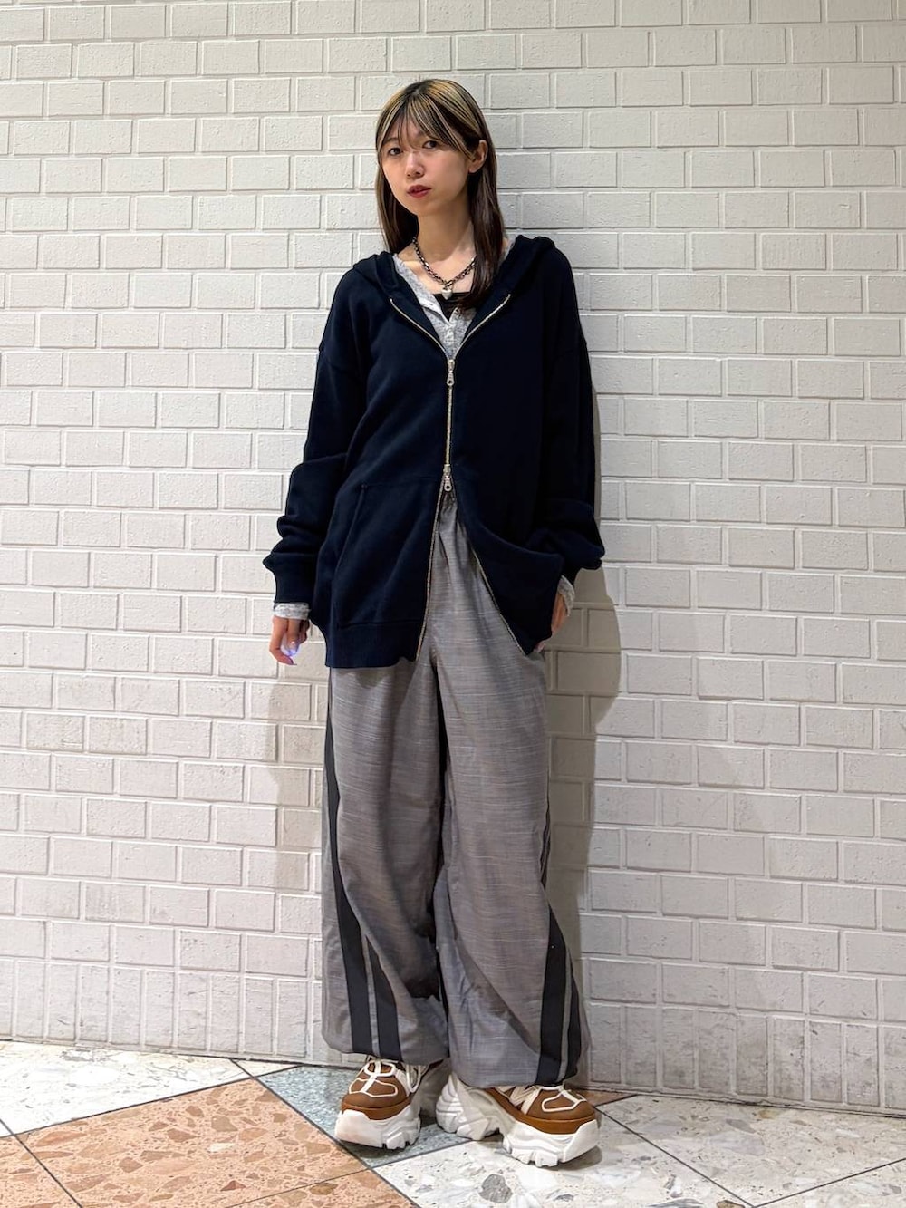 ベージュ系のスニーカー、ブルー系のパーカー、グレー系のその他パンツを着用したレディースの春コーディネートの4枚目の写真