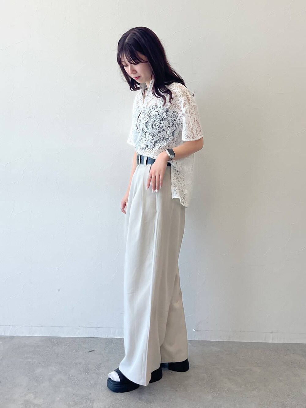 ホワイト系のシャツ/ブラウス、ブラック系のサンダル、ベージュ系のスラックスを着用したレディースの春コーディネートの2枚目の写真