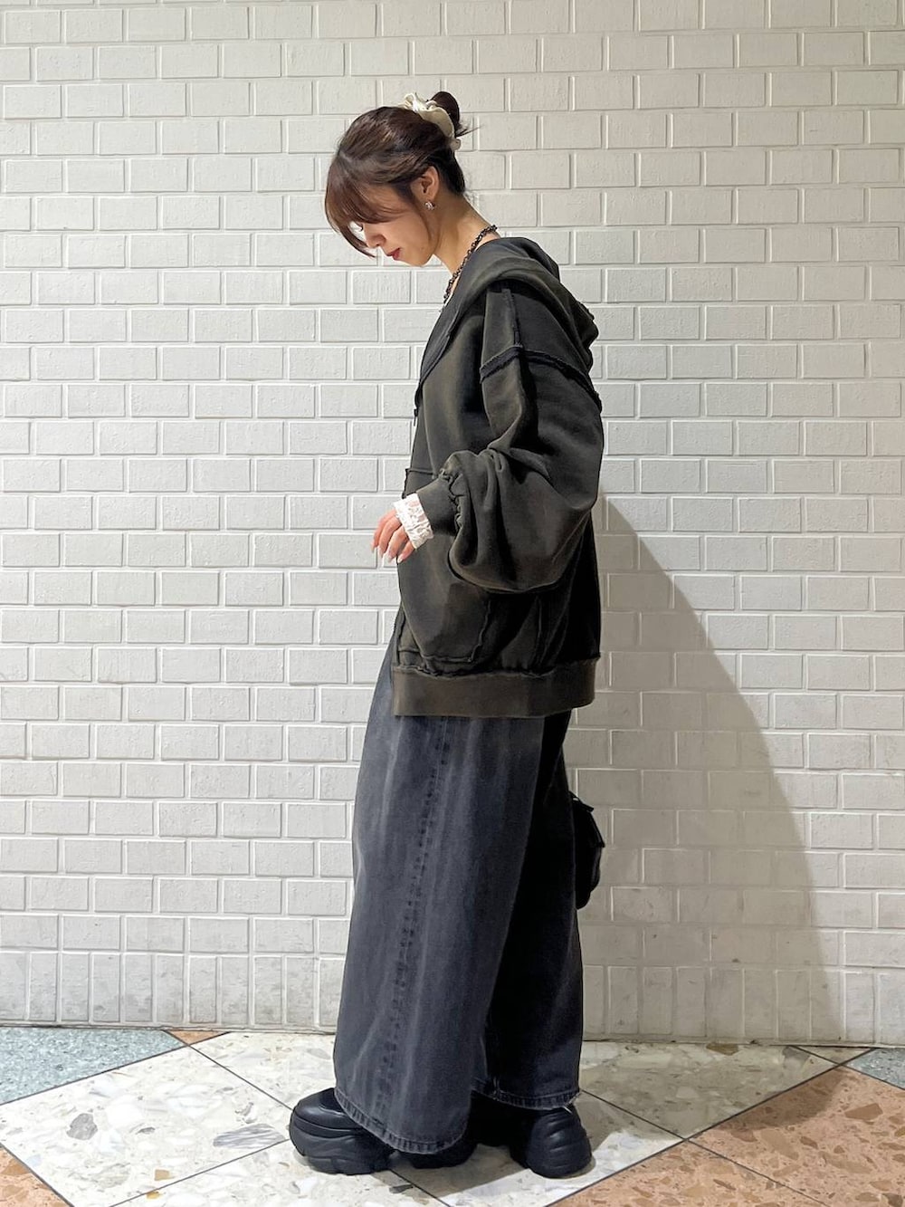 ブラック系のブーツ、ブラック系のデニムパンツ、ホワイト系のTシャツ/カットソーを着用したレディースの秋コーディネートの5枚目の写真
