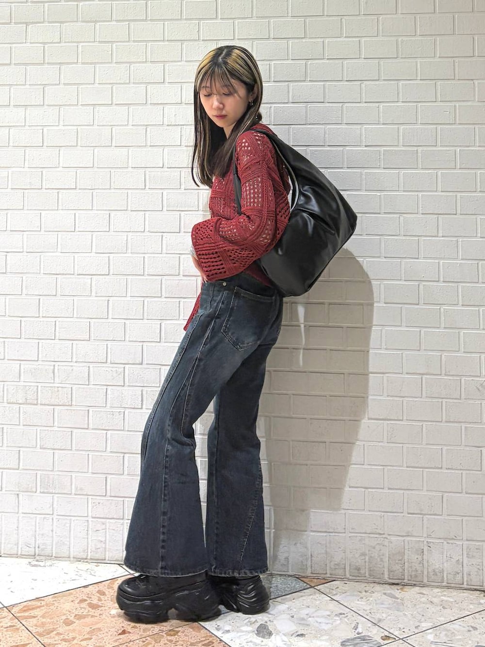 ブラック系のスニーカー、ブルー系のデニムパンツ、ブラック系のトートバッグを着用したレディースの春コーディネートの2枚目の写真