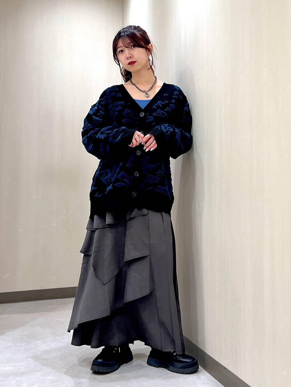 ブラウン系のスカート、ブルー系のキャミソール、ブラック系のカーディガン/ボレロを着用したレディースの冬コーディネートの4枚目の写真