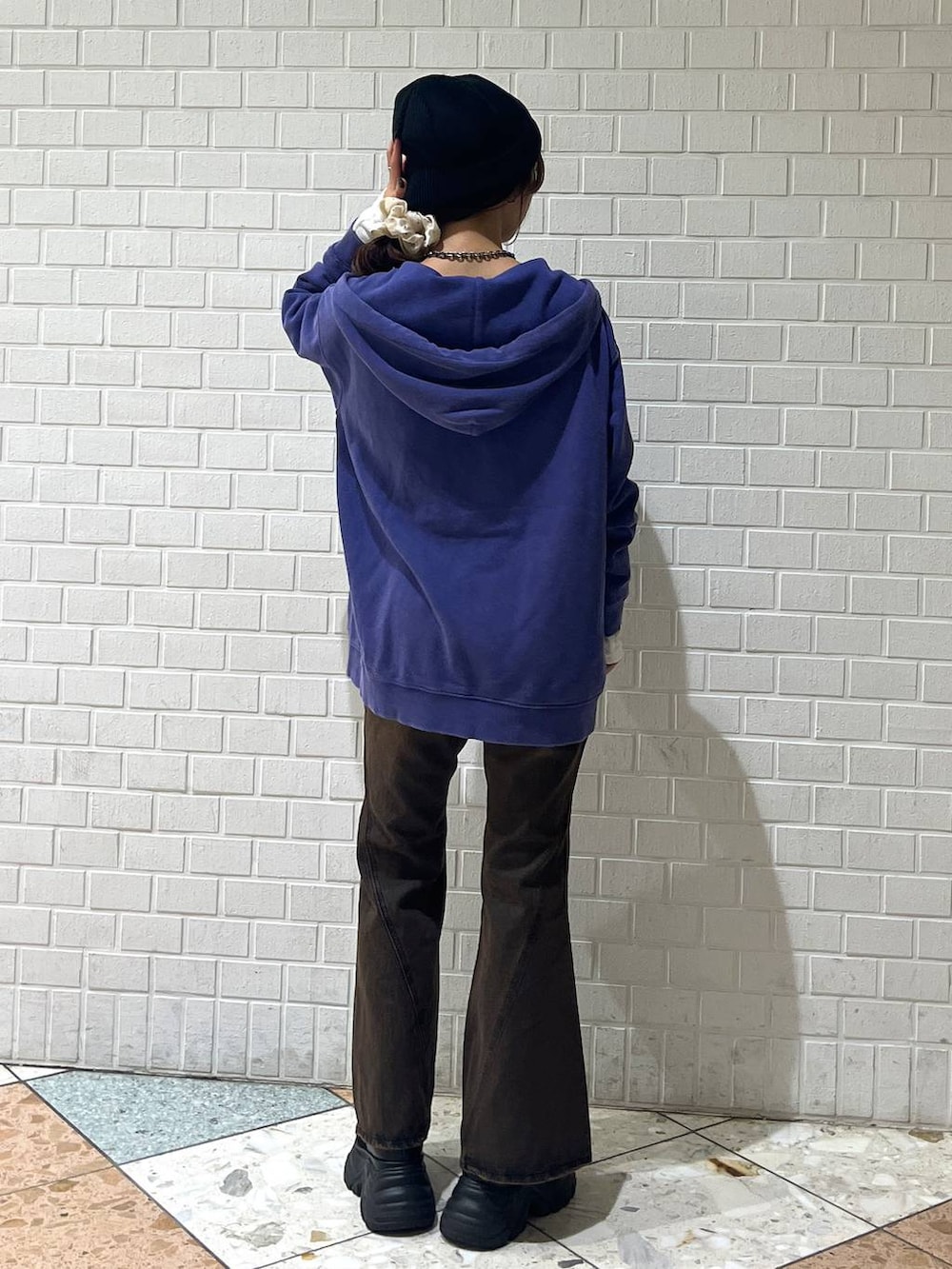 ブラック系のブーツ、ブラウン系のデニムパンツ、ブルー系のパーカーを着用したレディースの秋コーディネートの3枚目の写真