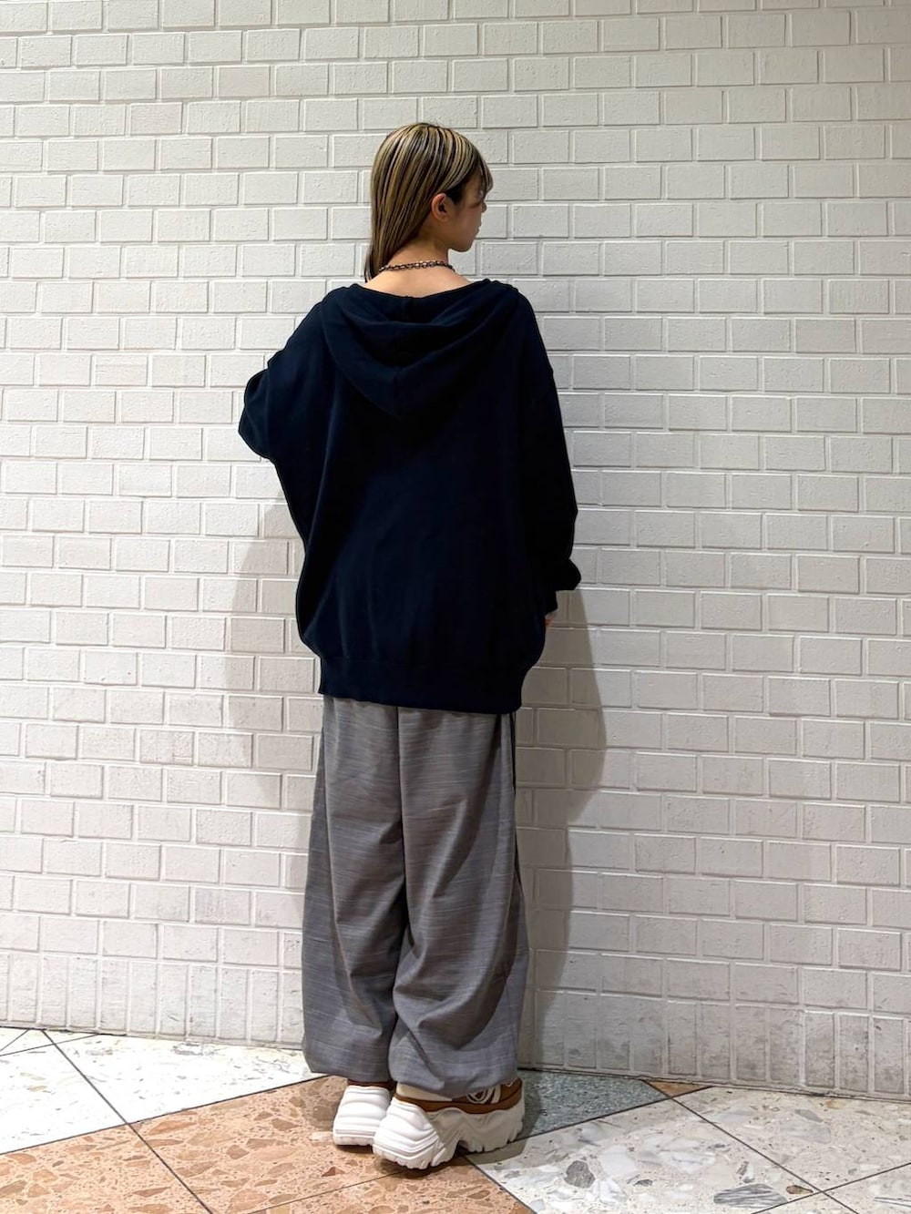 ベージュ系のスニーカー、ブルー系のパーカー、グレー系のその他パンツを着用したレディースの春コーディネートの5枚目の写真