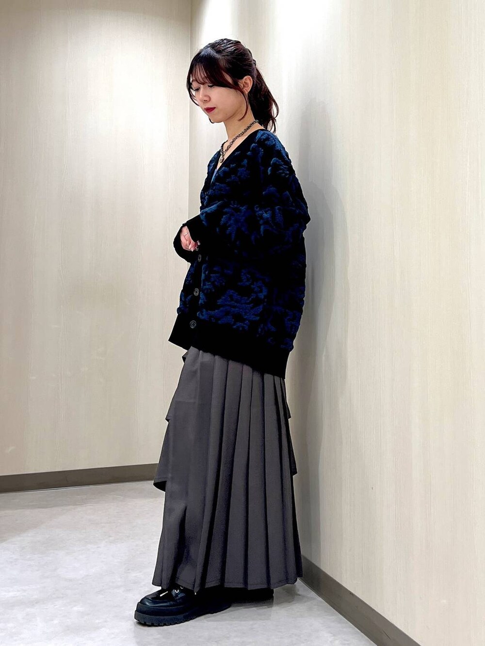 ブラウン系のスカート、ブルー系のキャミソール、ブラック系のカーディガン/ボレロを着用したレディースの冬コーディネートの2枚目の写真