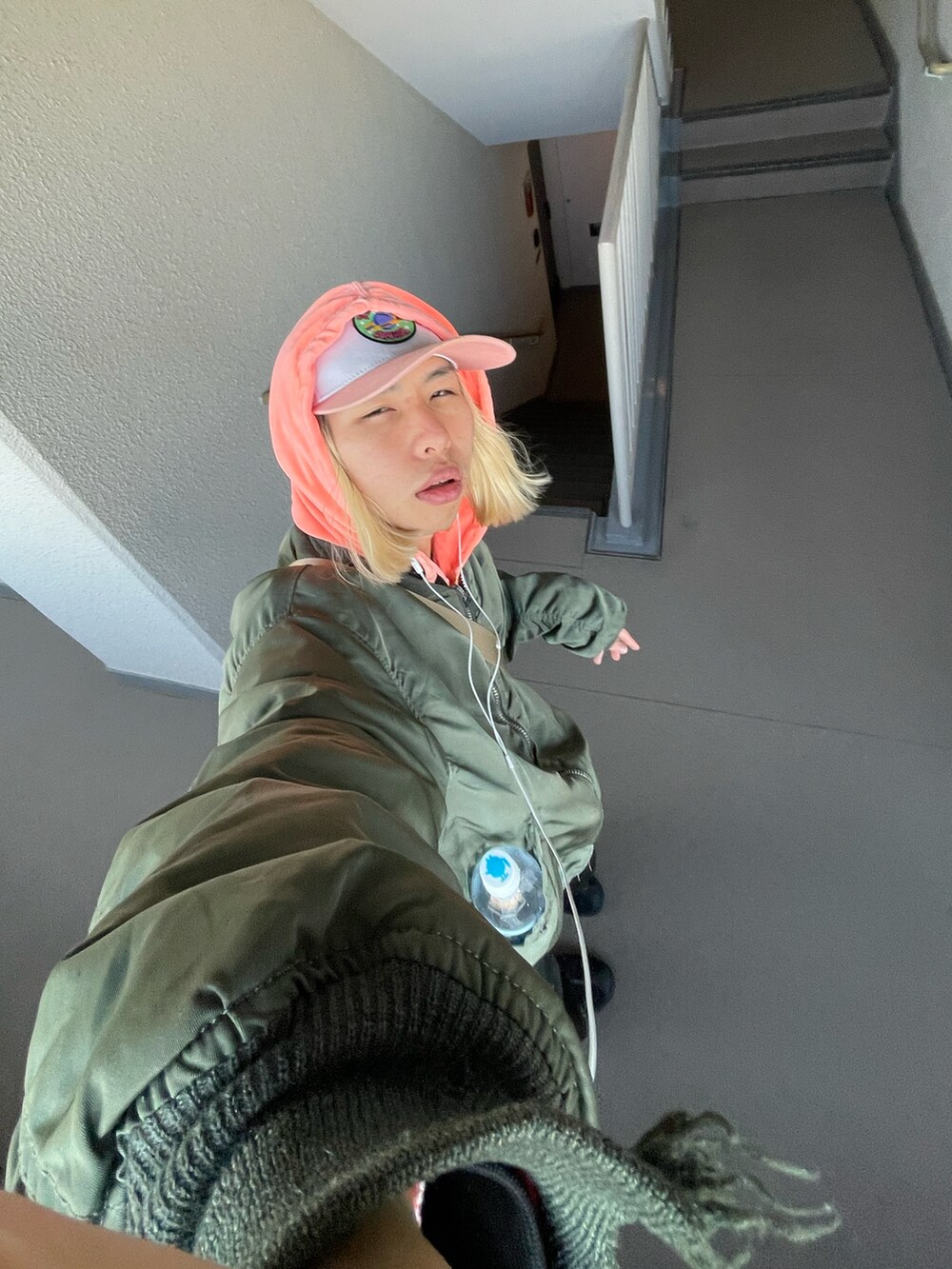 グリーン系のMA-1、ベージュ系のショルダーバッグ、ブラック系のパンツを着用したメンズの春コーディネートの4枚目の写真