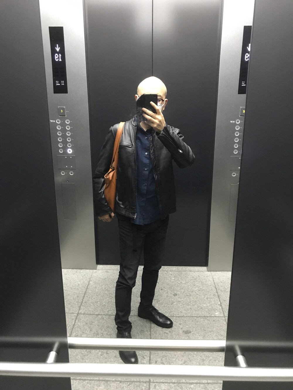 ブラック系のライダースジャケット、ブルー系のシャツ/ブラウス、ブルー系のデニムパンツを着用したメンズの春コーディネートの2枚目の写真