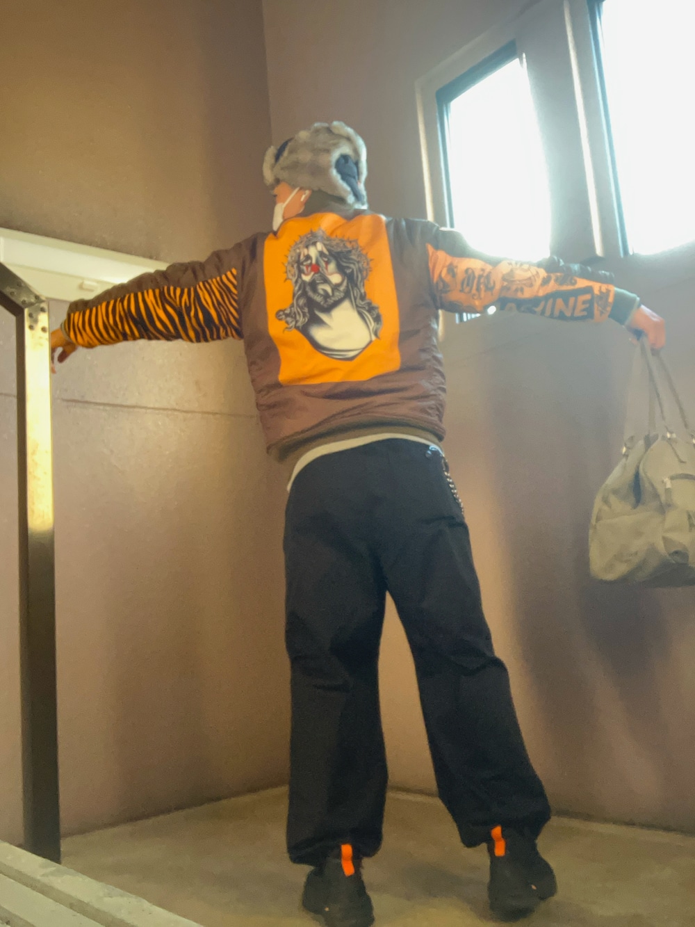 グリーン系のMA-1、ブラック系のカーゴパンツ、ブラック系のスニーカーを着用したメンズの冬コーディネートの2枚目の写真