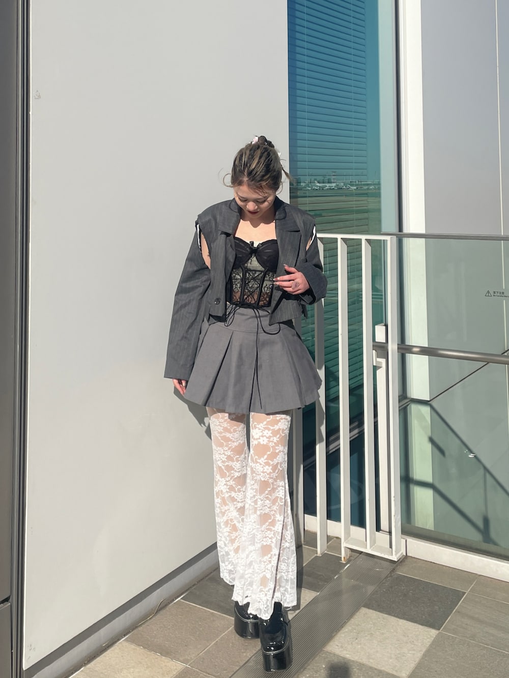 ブラック系のその他トップス、グレー系のスカート、グレー系のテーラードジャケットを着用したレディースの春コーディネートの3枚目の写真