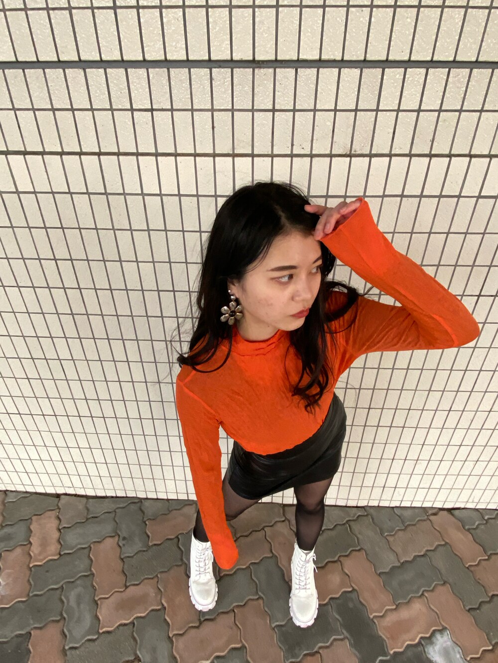 ブラック系のスカート、ゴールド系のピアス（両耳用）を着用したレディースの春コーディネートの2枚目の写真