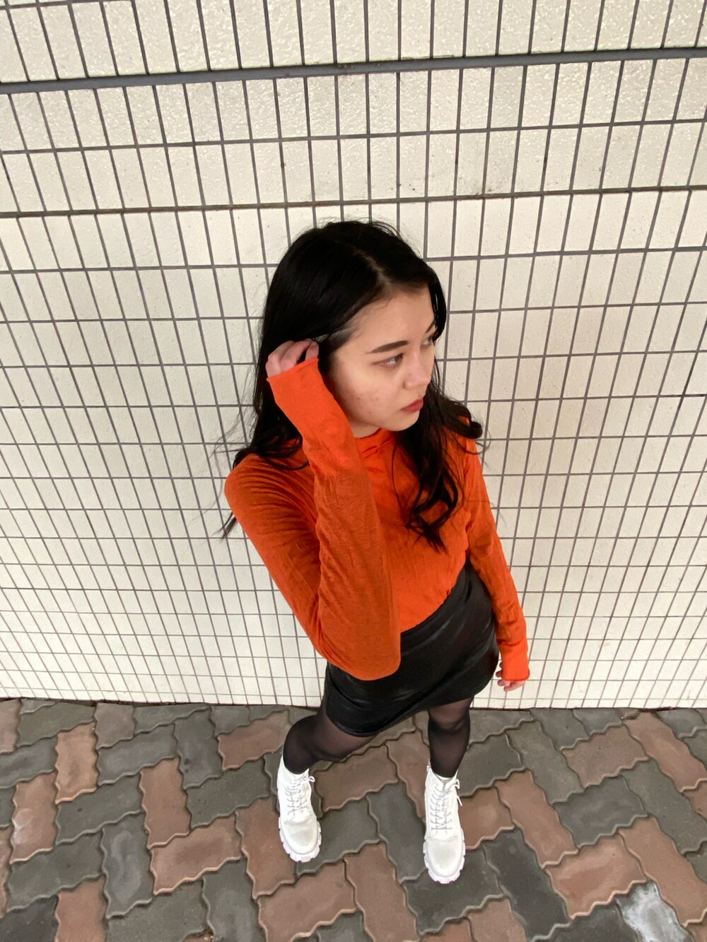 ブラック系のスカート、ゴールド系のピアス（両耳用）を着用したレディースの春コーディネートの3枚目の写真