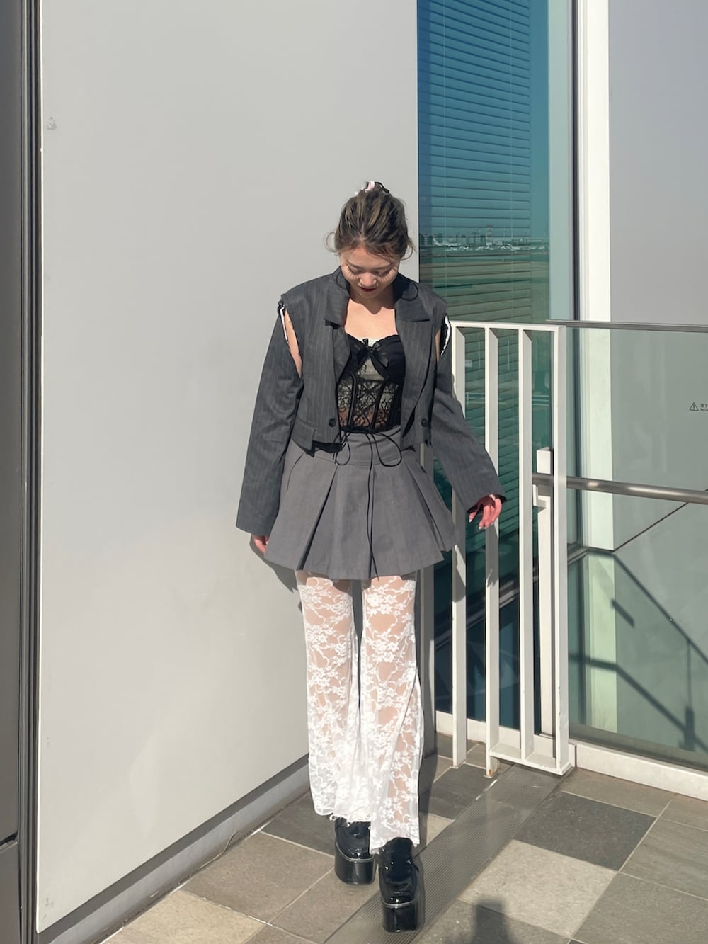 ブラック系のその他トップス、グレー系のスカート、グレー系のテーラードジャケットを着用したレディースの春コーディネートの2枚目の写真