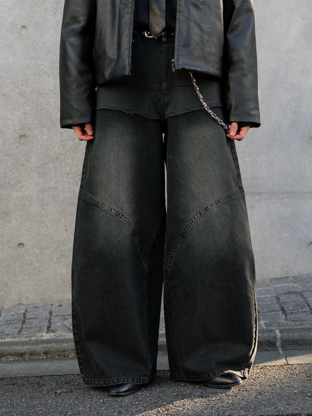 ブラック系のダウンジャケット/コート、ブラウン系のデニムパンツを着用したメンズの秋コーディネートの4枚目の写真