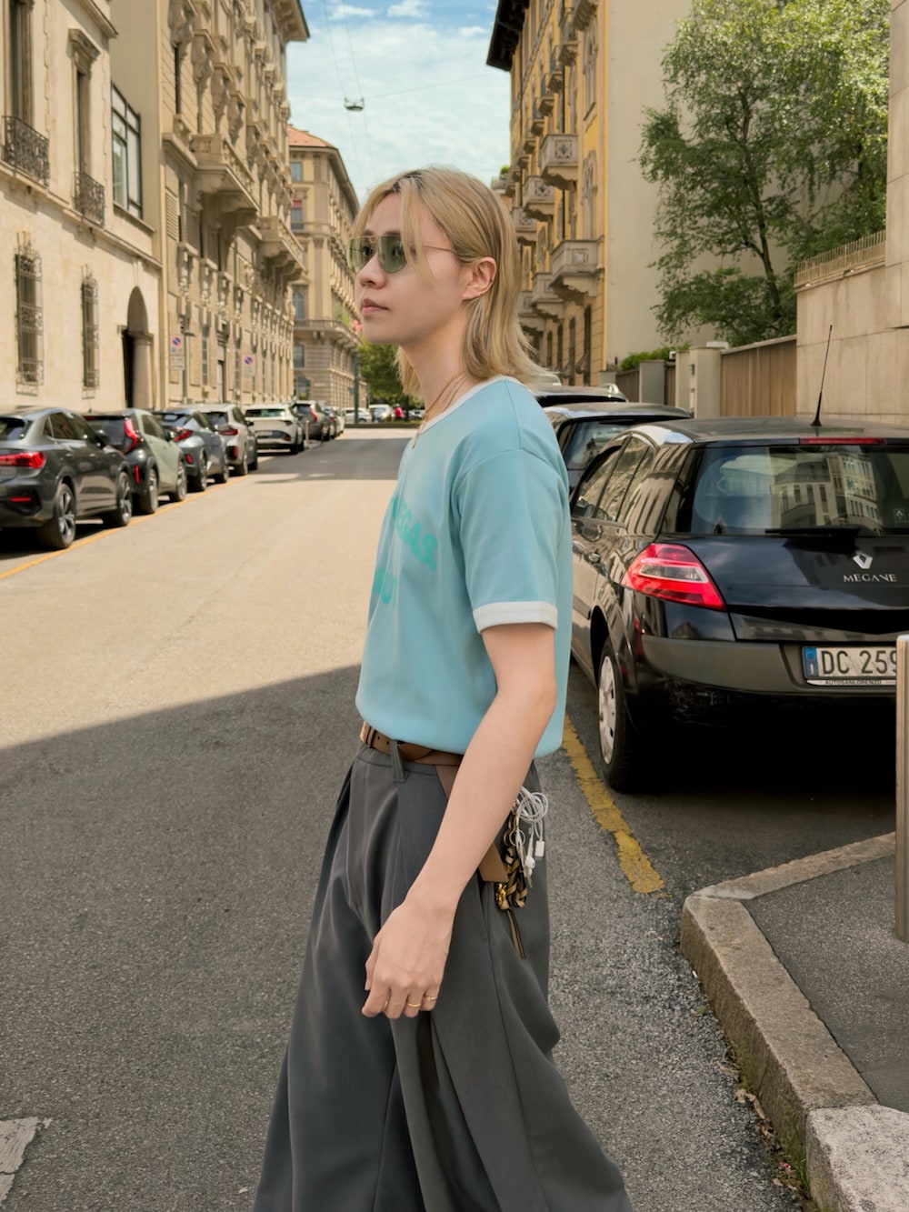 ブルー系のTシャツ/カットソー、グレー系のスラックス、ホワイト系のサンダルを着用したメンズの夏コーディネートの4枚目の写真