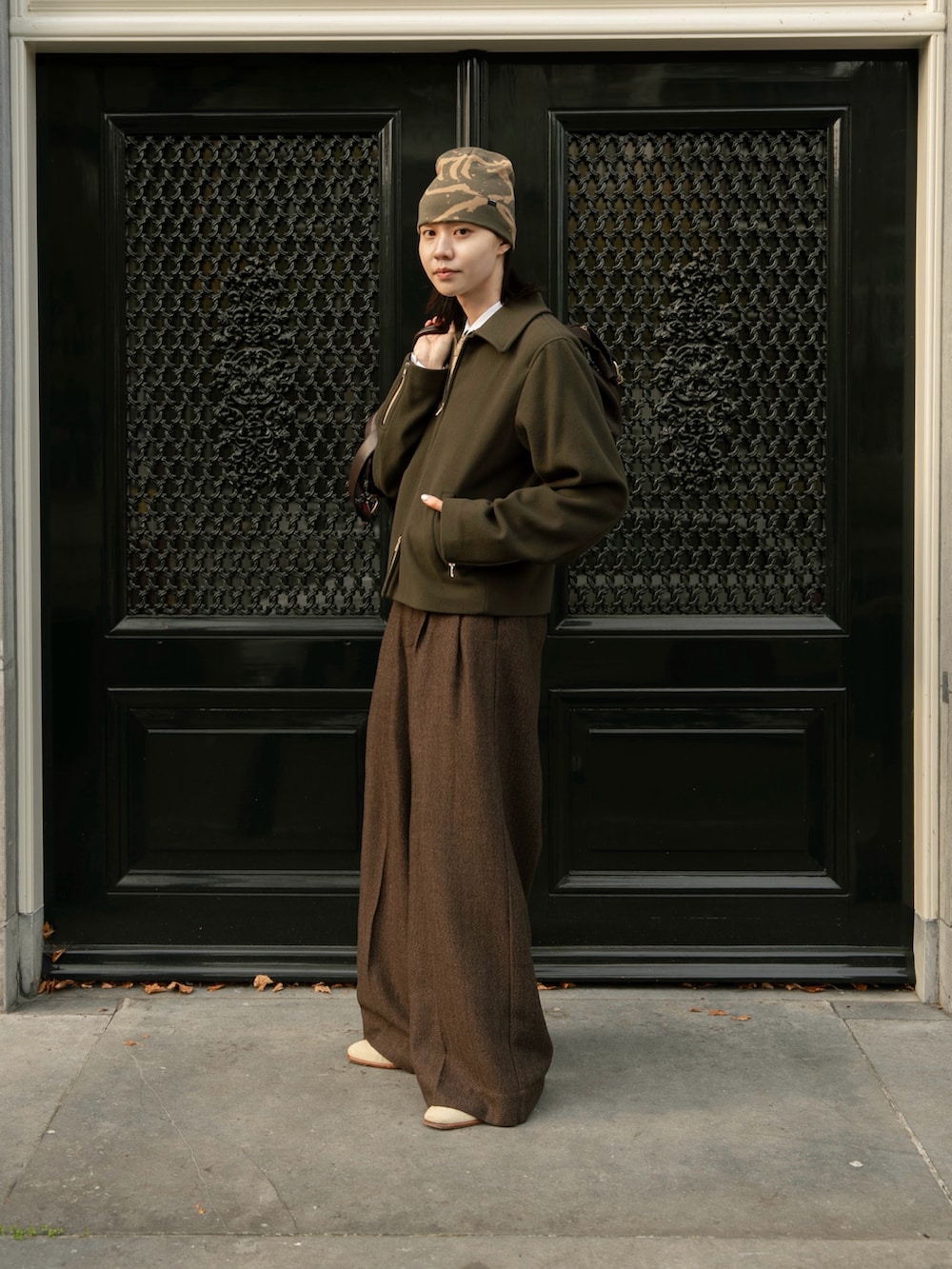 ブラウン系のスラックス、グリーン系のジャケット/アウター、ブラウン系のボストンバッグを着用したメンズの秋コーディネートの4枚目の写真