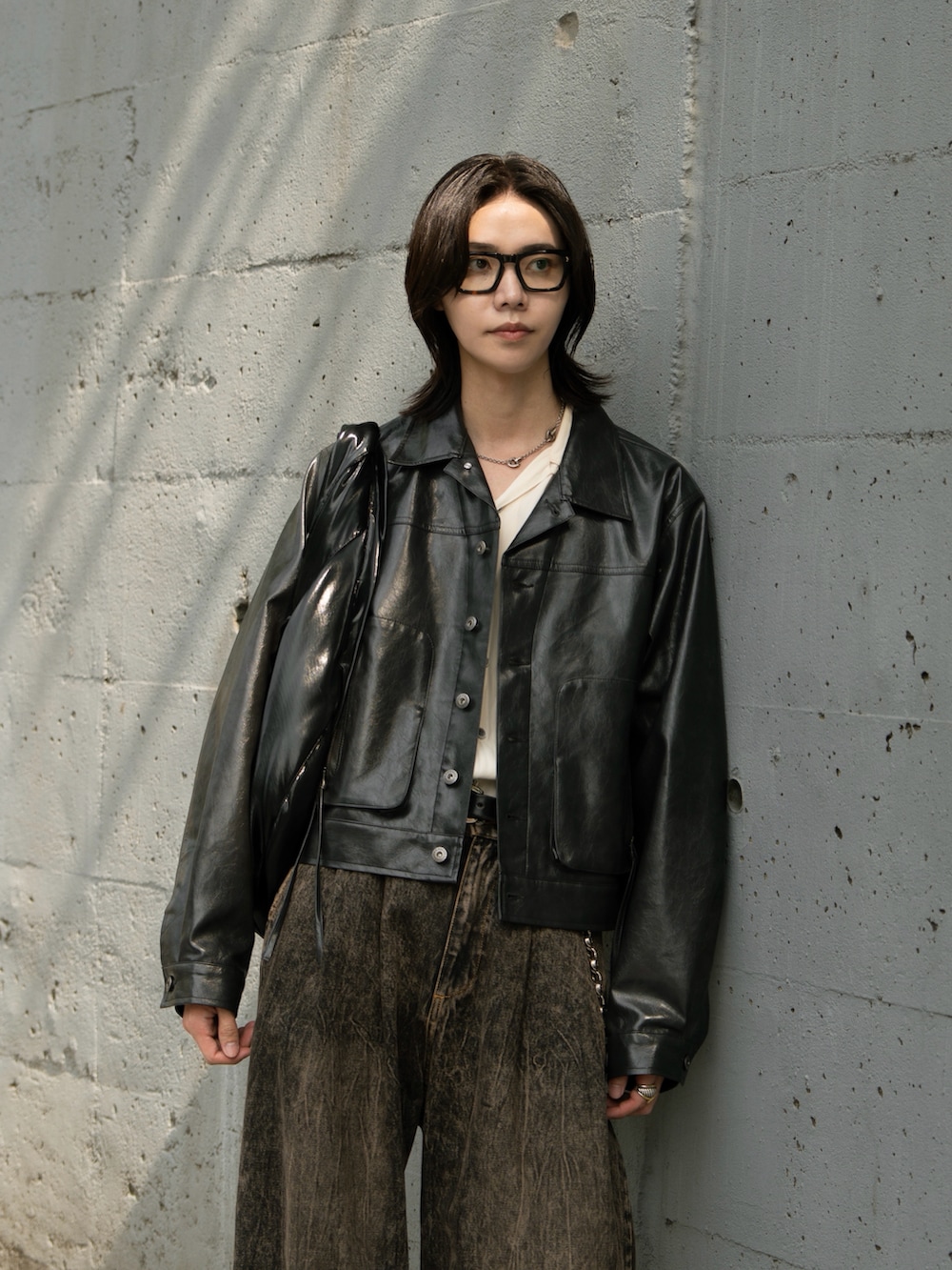 ブラック系のその他アウター、ブラウン系のデニムパンツを着用したメンズの秋コーディネートの2枚目の写真