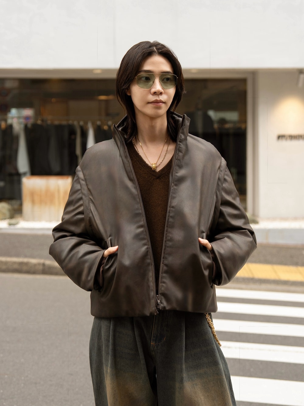 ブルー系のデニムパンツ、ブラウン系のダウンジャケット/コートを着用したメンズの秋コーディネートの4枚目の写真