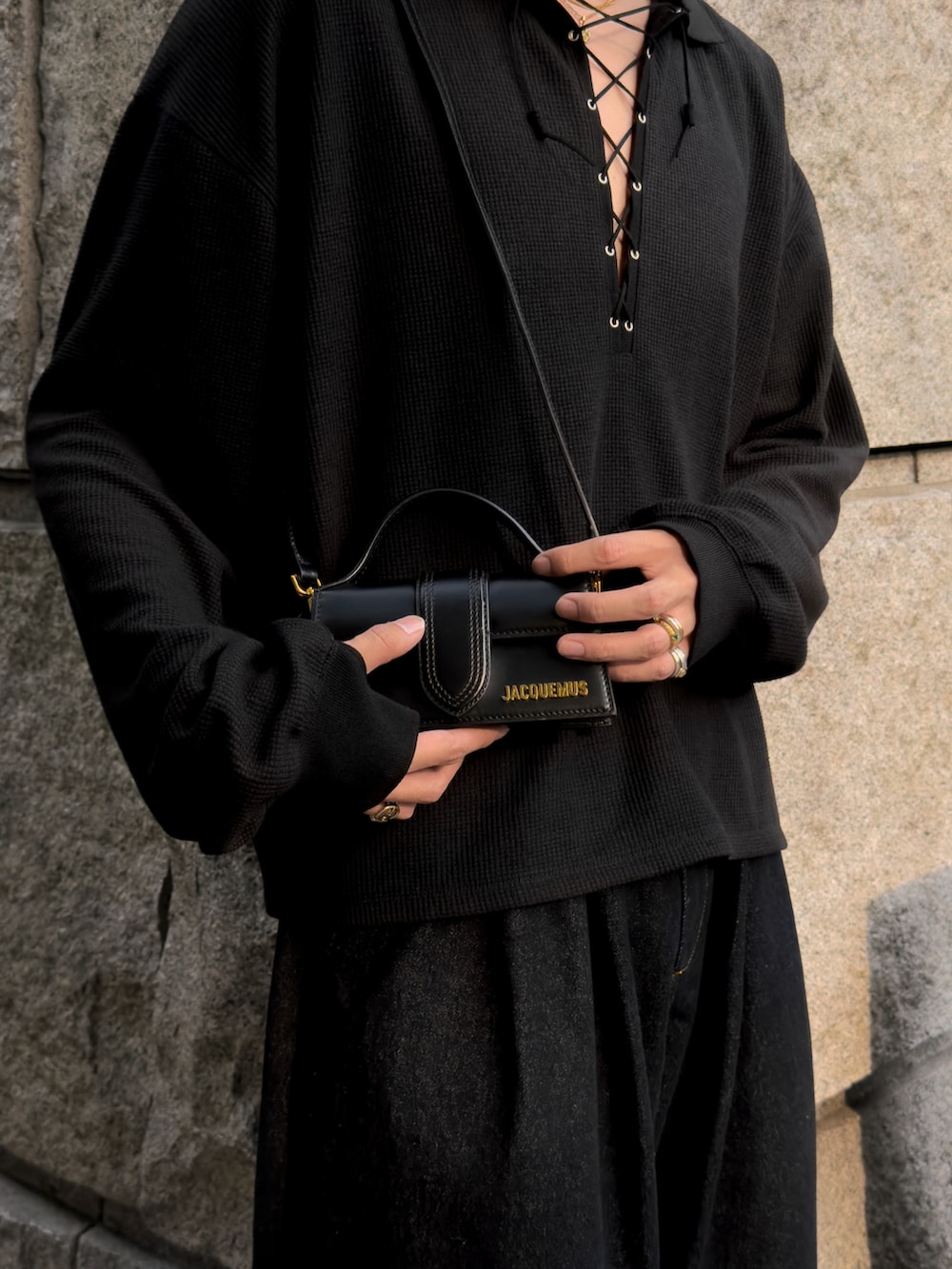 ブルー系のデニムパンツ、ブラック系のハンドバッグ、ブラック系のドレスシューズを着用したメンズの夏コーディネートの4枚目の写真