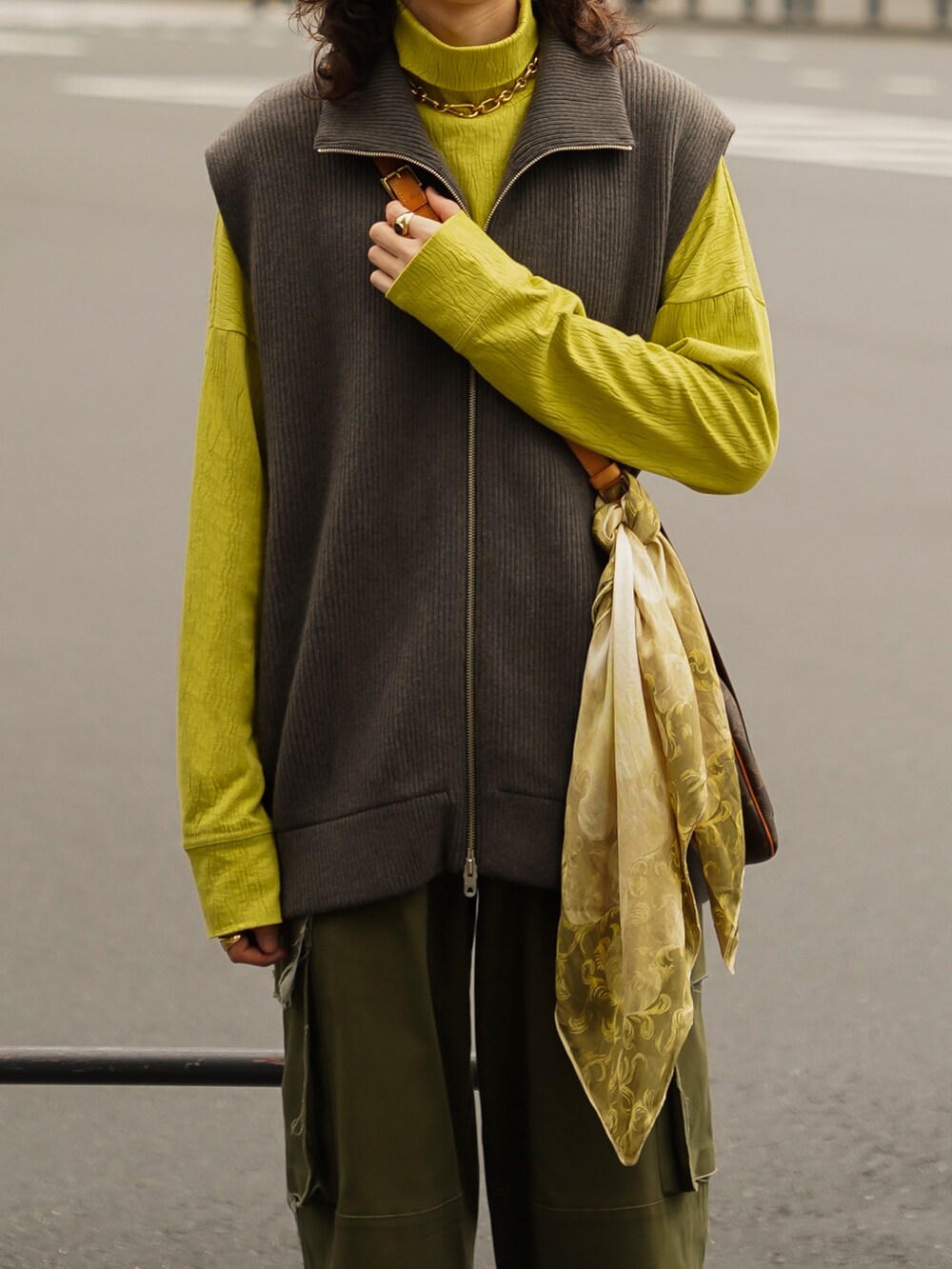 グレー系のベスト、グリーン系のカーゴパンツ、グリーン系のTシャツ/カットソーを着用したメンズの秋コーディネートの4枚目の写真
