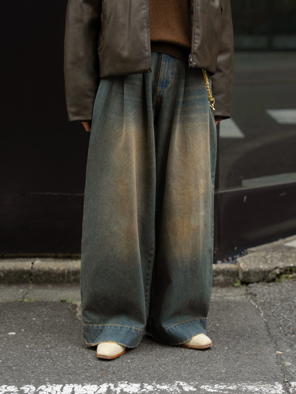 ブルー系のデニムパンツ、ブラウン系のダウンジャケット/コートを着用したメンズの秋コーディネートの5枚目の写真