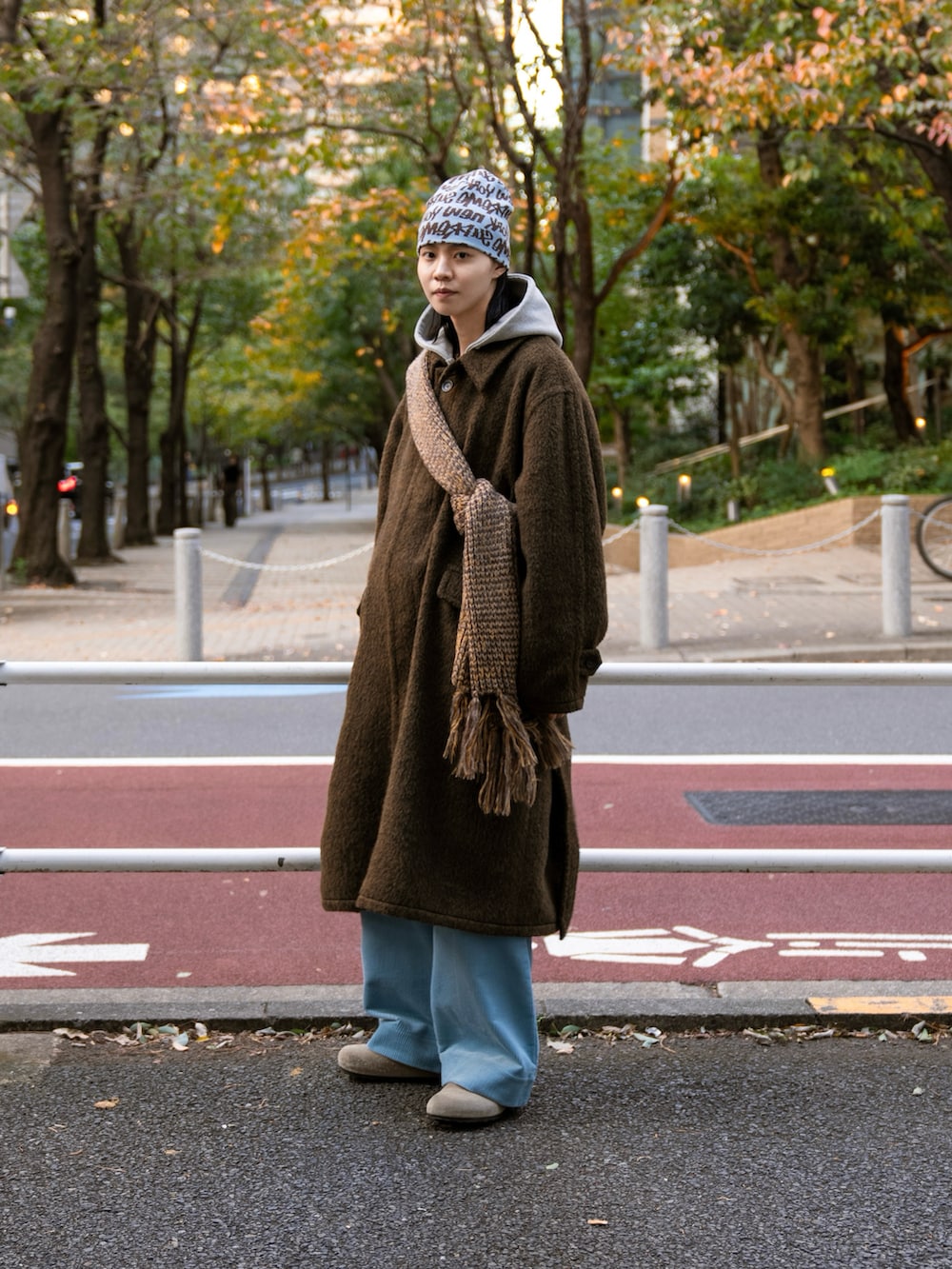 ブラック系のステンカラーコート、ベージュ系のその他パンツ、グレー系のパーカーを着用したメンズの秋コーディネートの4枚目の写真